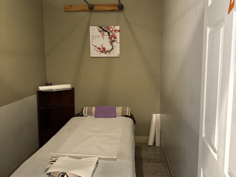 Private massage room with a freshly made table and a Quiet Please sign on the door